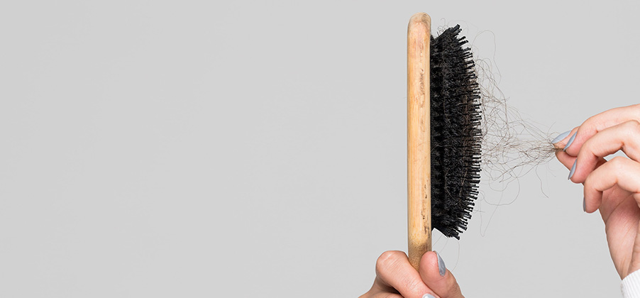 hand die haren uit een borstel trekt, vanwege haaruitval